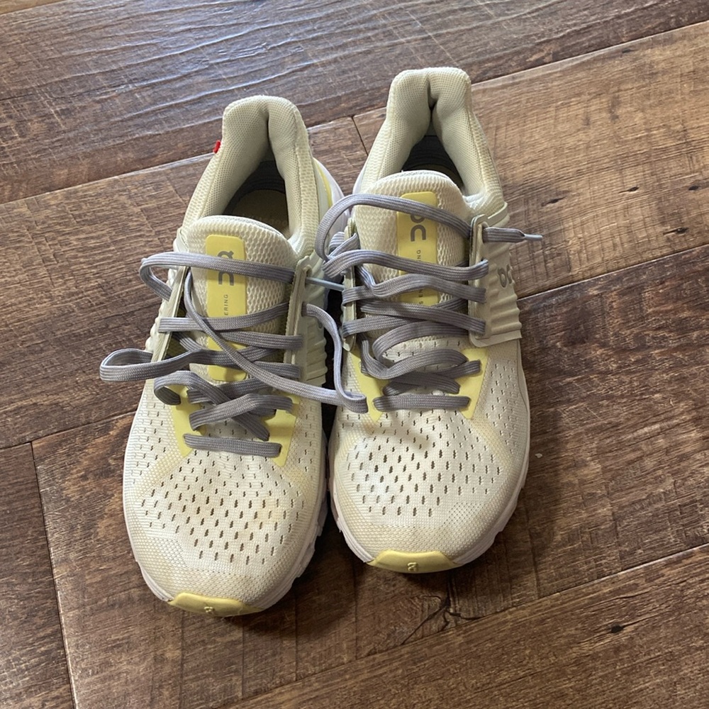On tennis shoes. White, grey and yellow. Size 6